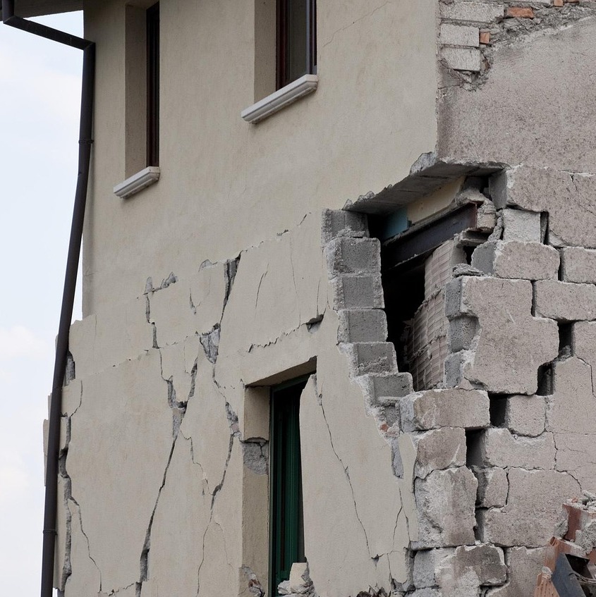 Brick siding hangs loosely from a building after an earthquake