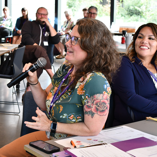 An attendee asks a question of a speaker