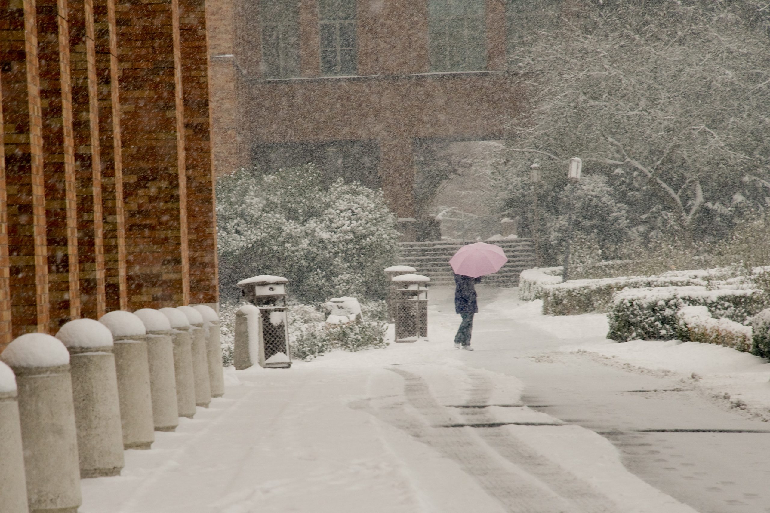 A person walks across a street during a snow day
