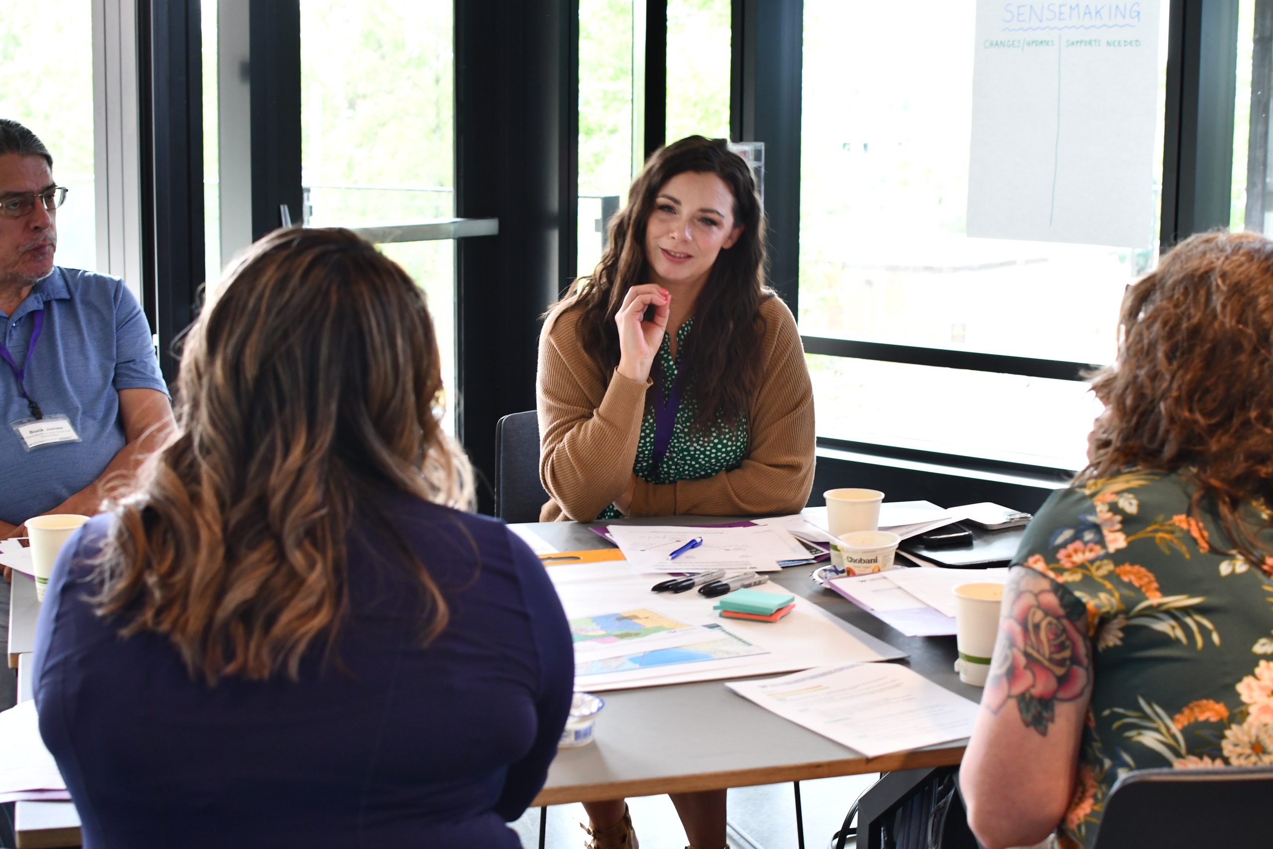 A group of people engage in a discussion while seated at a table