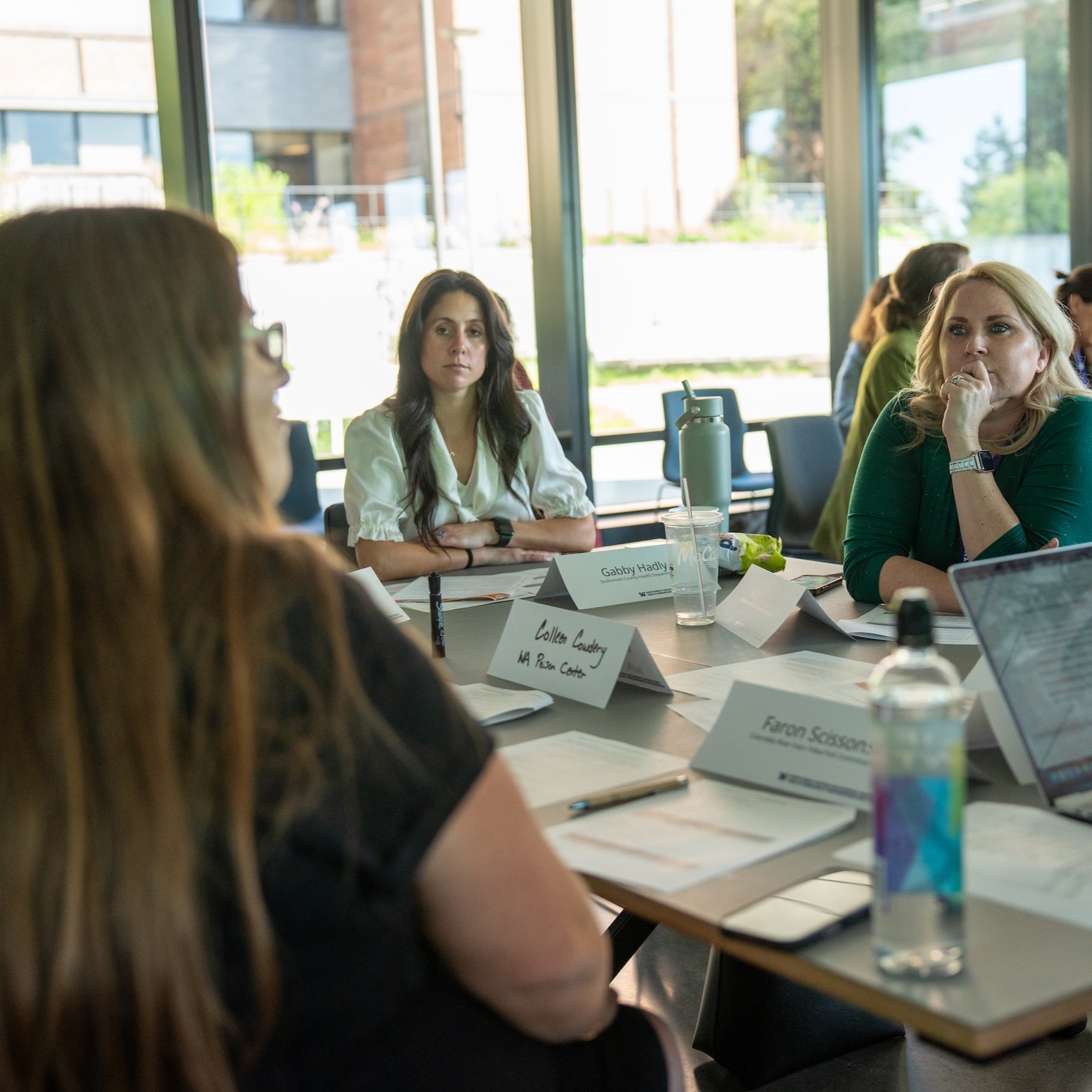 Several of the institute attendees engage in a discussion while seated around a table