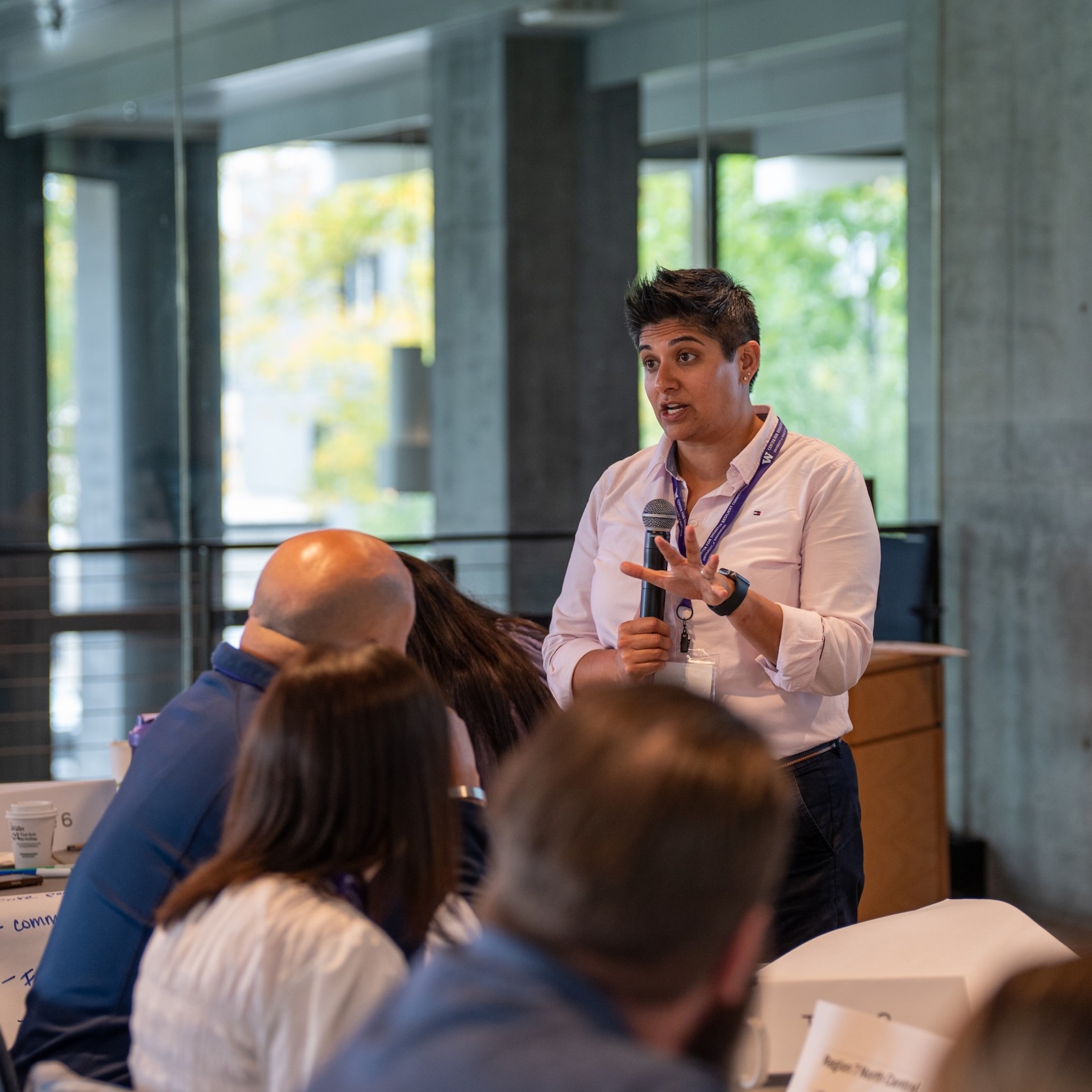 A course facilitator speaks to attendees while holding a microphone